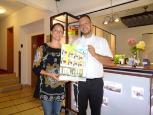 Nina Ferstl und Konstantin Schatz posieren mit Gemälde des Hotel Brunner Amberg.
